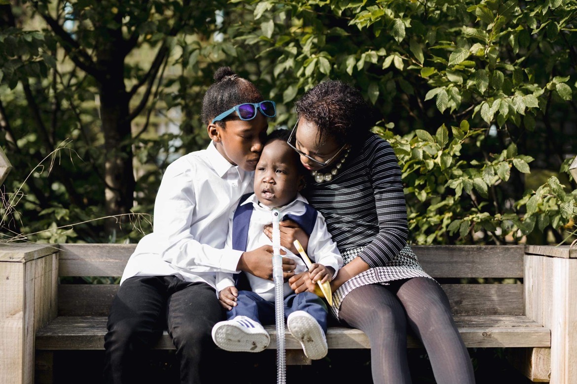 Elienai and Eliedad sitting with their brother Nathan at Ronald McDonald House Manchester. Credit: Adam Hudson.