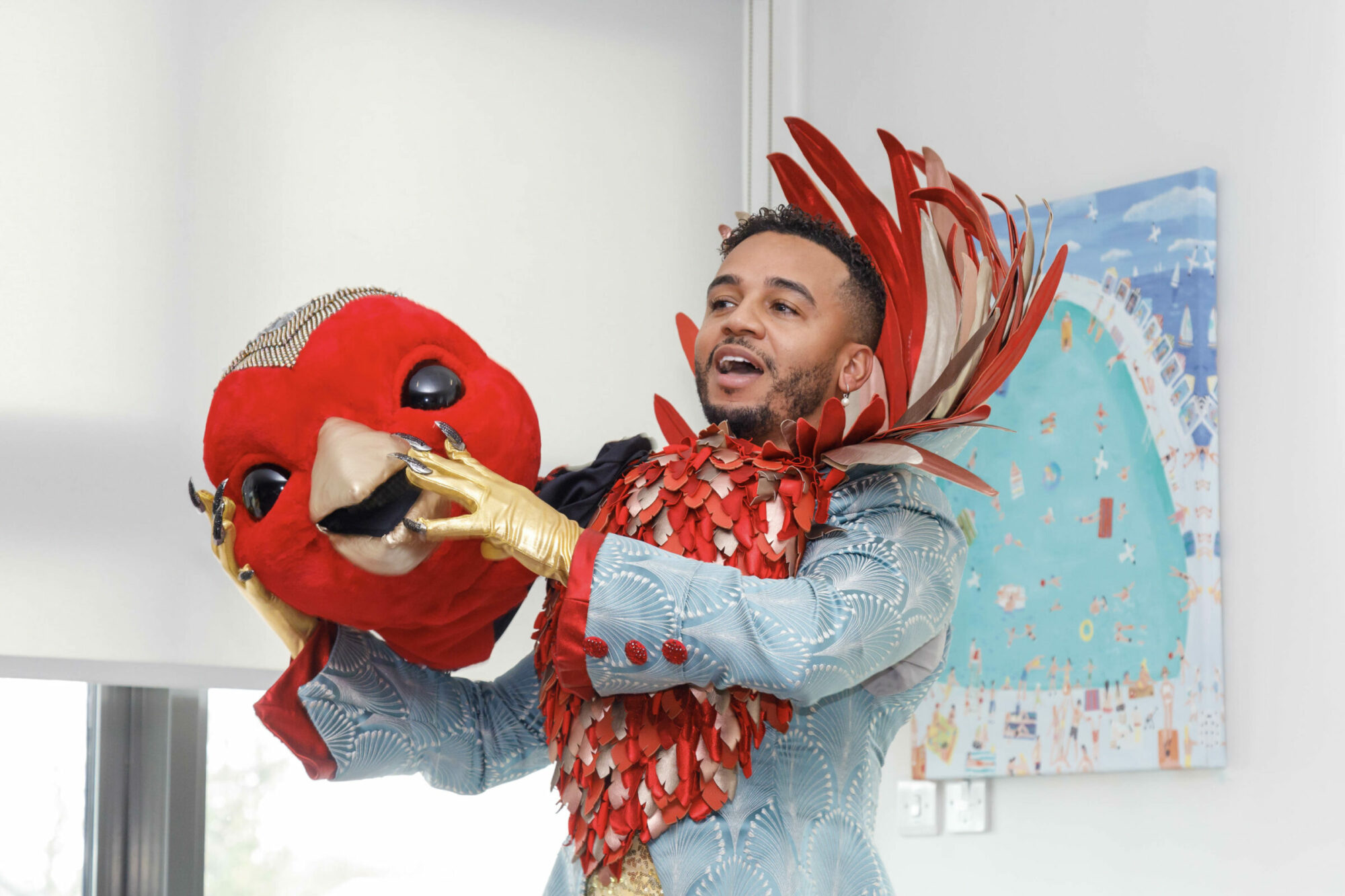 Masked Singer star Aston Merrygold takes off his Robin mask to perform for families.