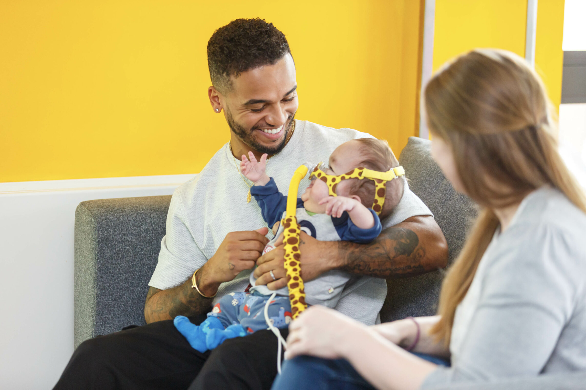 Masked Singer star Aston Merrygold holds baby Ezra as he speaks to his mum.