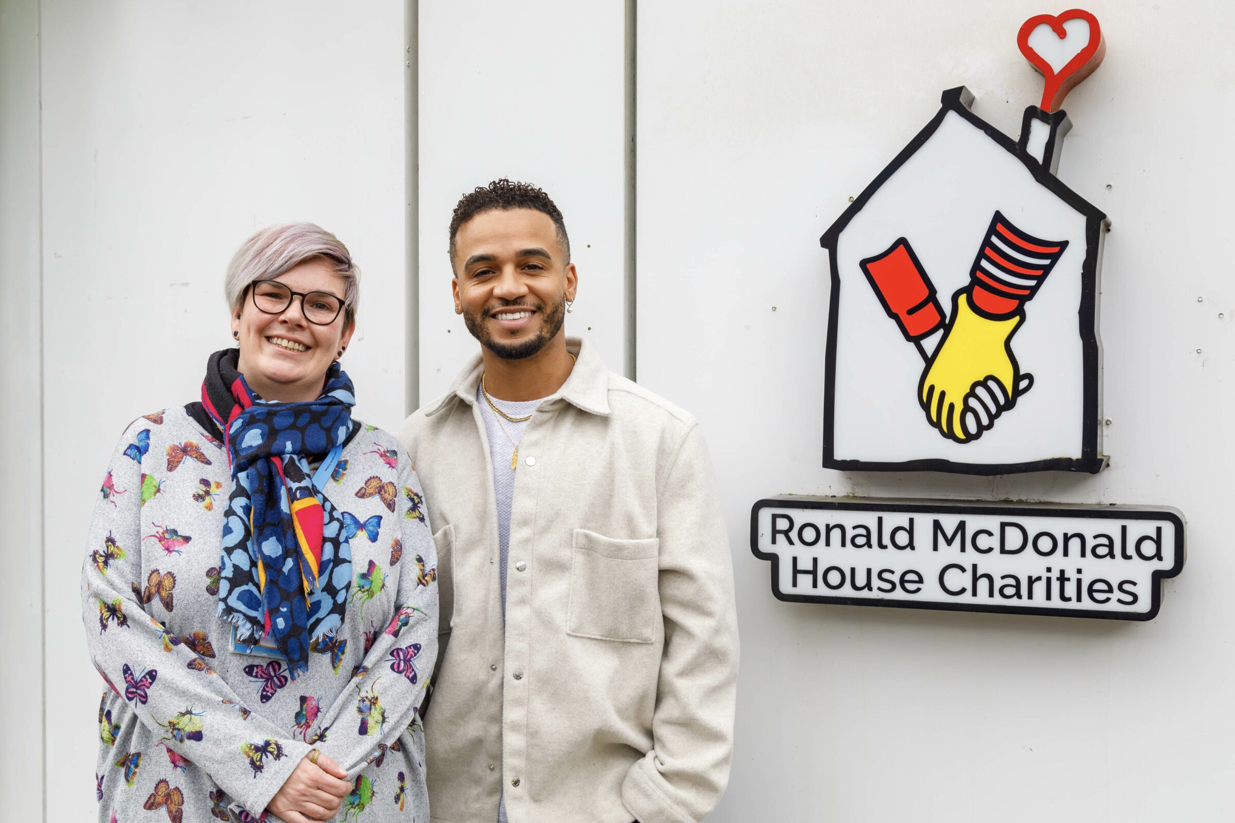 Masked Signer star Aston Merrygold with Deputy House Manager Becky Baines outside the Ronald McDonald House Southampton.